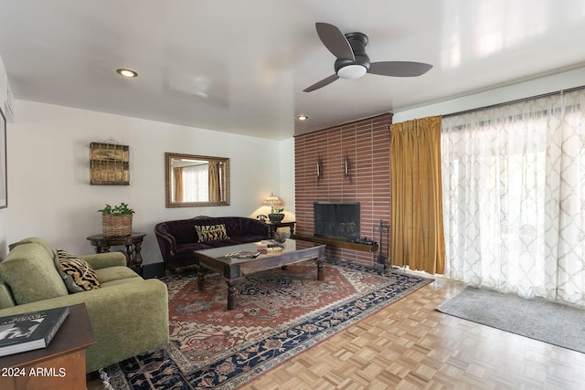 living room featuring ceiling fan, parquet flooring, and a brick fireplace