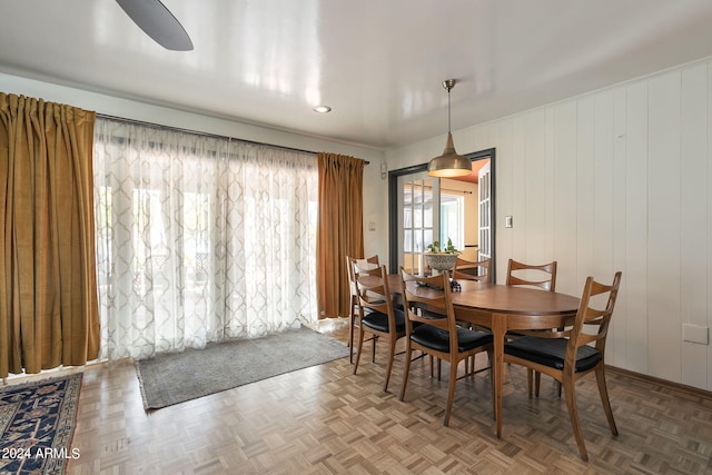 dining space with ceiling fan and parquet floors