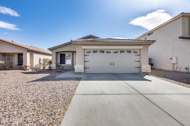 view of front of home with a tile roof, stucco siding, concrete driveway, and a garage