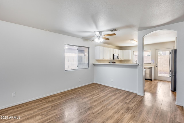 kitchen with light wood-style floors, visible vents, a wealth of natural light, and stainless steel appliances