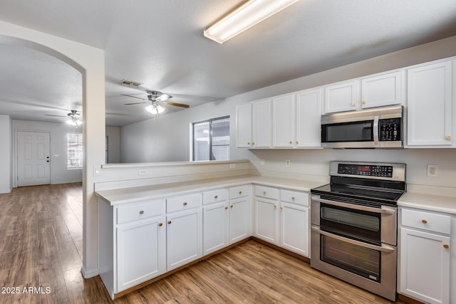 kitchen with light countertops, light wood finished floors, visible vents, and appliances with stainless steel finishes