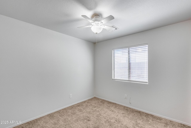 empty room featuring baseboards, light carpet, a textured ceiling, and ceiling fan