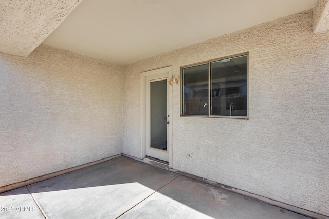 entrance to property with stucco siding and a patio