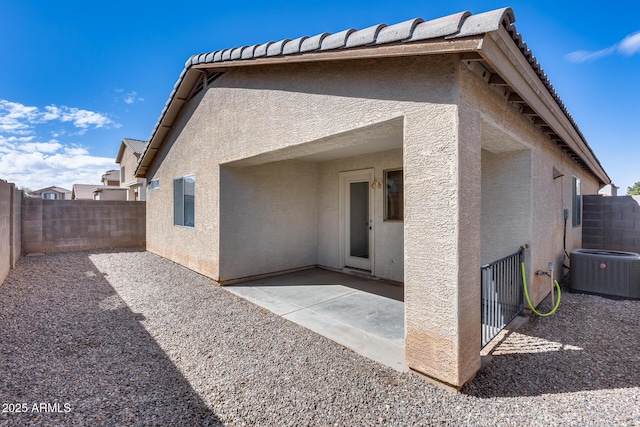 rear view of property with stucco siding, a patio, and a fenced backyard