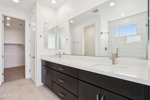 10253 E Ursula Ave, Mesa, AZ 85212 - bathroom featuring double vanity, tiled shower, recessed lighting, a walk in closet, and baseboards