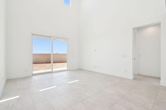 10253 E Ursula Ave, Mesa, AZ 85212 - unfurnished room featuring light tile patterned flooring, a towering ceiling, and baseboards