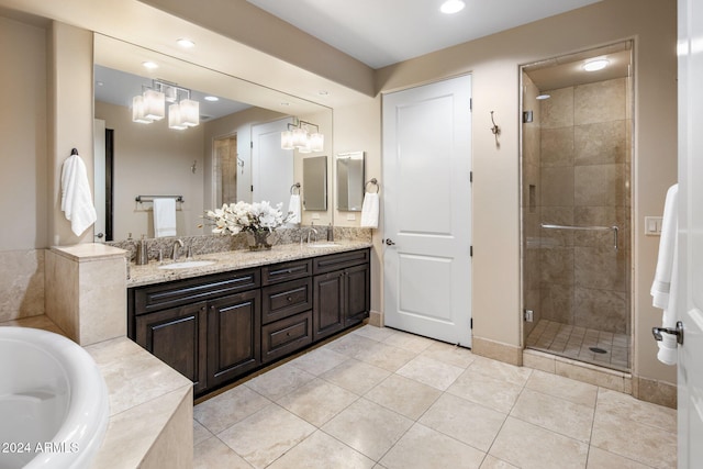 bathroom with tile patterned flooring, vanity, a chandelier, and independent shower and bath