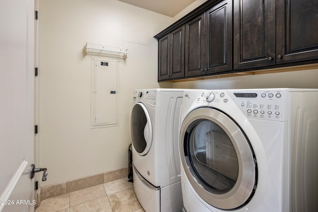 laundry area with light tile patterned flooring, electric panel, cabinets, and washing machine and clothes dryer