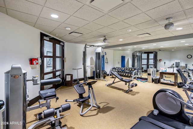 exercise room with carpet flooring and a paneled ceiling