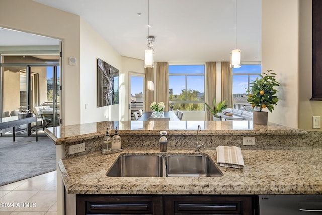 kitchen with pendant lighting, sink, light carpet, and light stone countertops