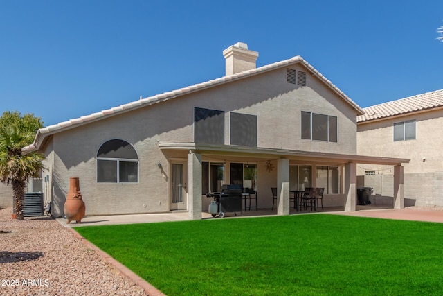 rear view of house featuring a yard and a patio