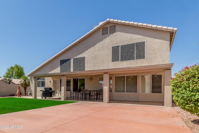 back of property featuring a lawn and a patio