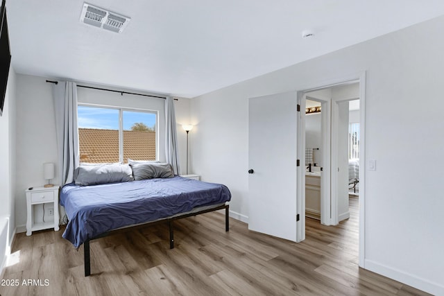 bedroom with visible vents, baseboards, and light wood-style flooring