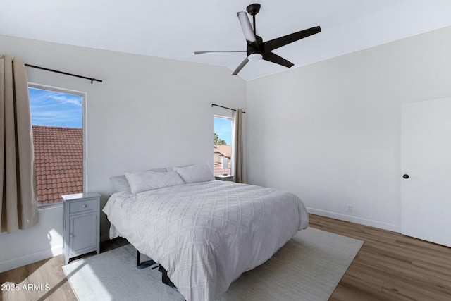 bedroom with lofted ceiling, baseboards, light wood-type flooring, and ceiling fan