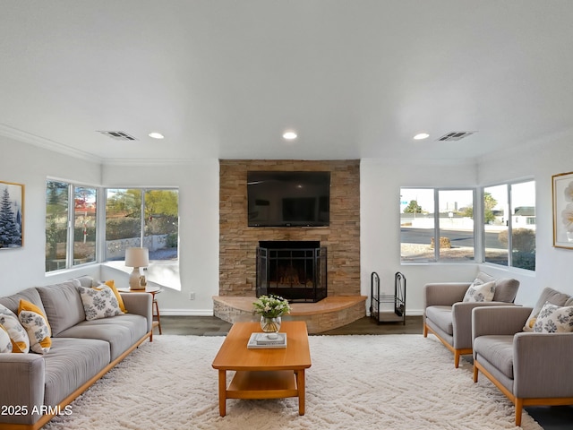 living room featuring a fireplace, crown molding, and hardwood / wood-style floors