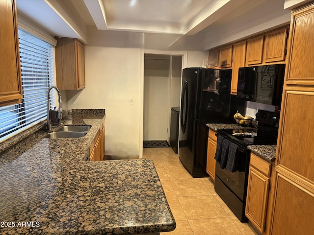 1001 N Pasadena St Unit 162, Mesa, AZ 85201 - kitchen featuring black appliances, a sink, a tray ceiling, light tile patterned floors, and brown cabinetry