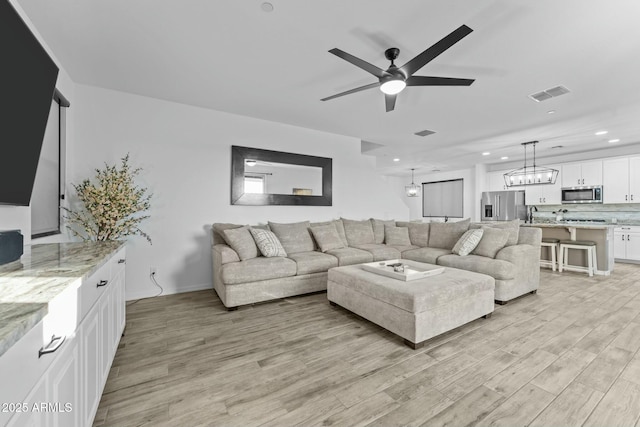 living room with ceiling fan and light hardwood / wood-style floors