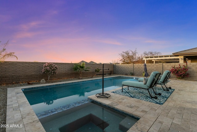 pool at dusk with an in ground hot tub