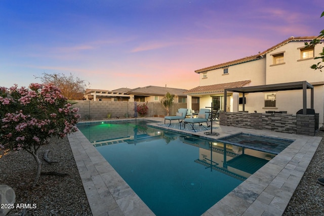 pool at dusk featuring exterior kitchen, an in ground hot tub, and a patio