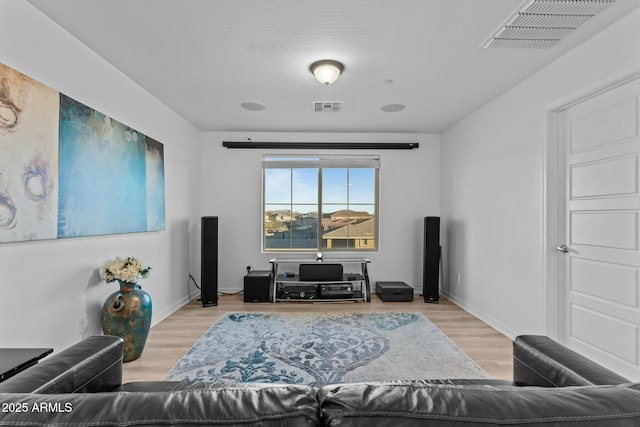 living room with a textured ceiling and light hardwood / wood-style flooring