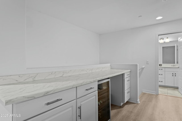 kitchen featuring white cabinets, light wood-type flooring, and wine cooler