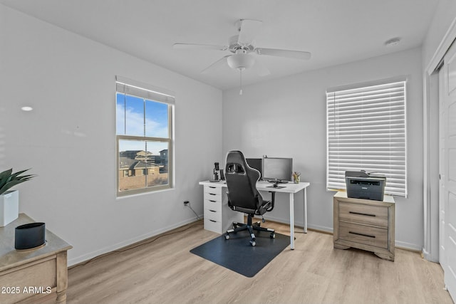 home office with light wood-type flooring and ceiling fan