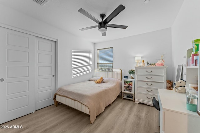 bedroom featuring light wood-type flooring, a closet, and ceiling fan