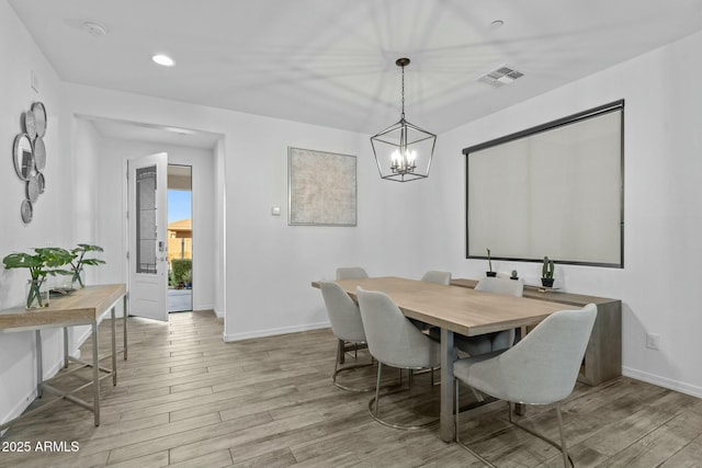 dining room featuring light wood-type flooring and a chandelier