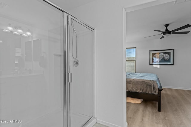 bathroom with ceiling fan, wood-type flooring, and an enclosed shower