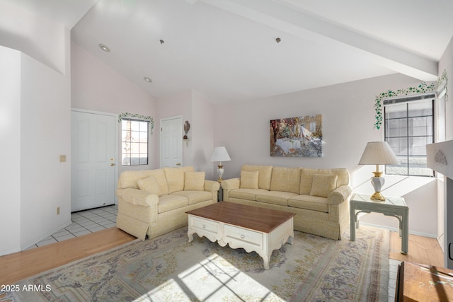 living room with light wood-type flooring, beam ceiling, and high vaulted ceiling