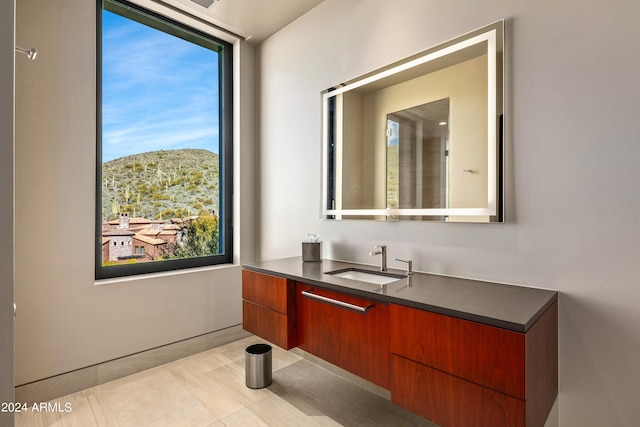 bathroom with a wealth of natural light, vanity, and tile patterned flooring