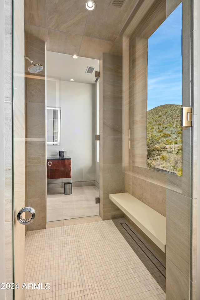 bathroom with tiled shower, a mountain view, and tile patterned flooring