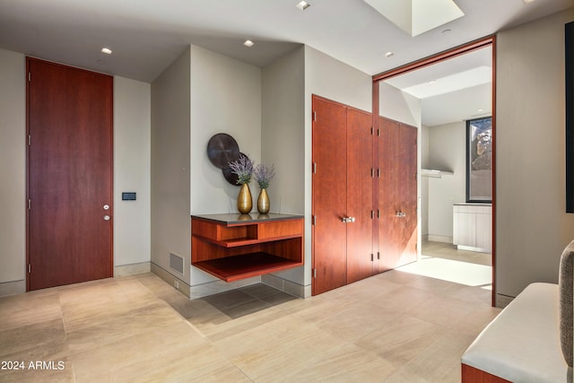 interior space featuring a skylight and light tile patterned floors