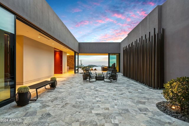 patio terrace at dusk featuring an outdoor hangout area