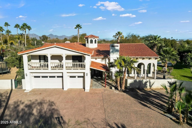 mediterranean / spanish-style home featuring a mountain view, a garage, and a balcony