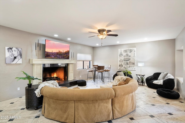 living room with ceiling fan and a fireplace