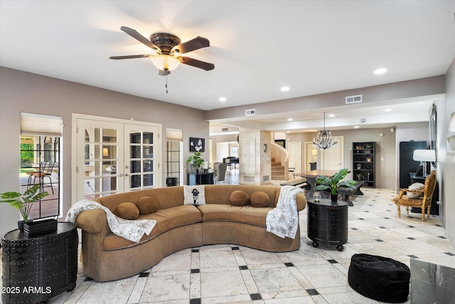 living room with ceiling fan with notable chandelier and french doors