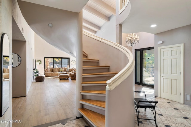 entrance foyer featuring high vaulted ceiling, a chandelier, wooden ceiling, beam ceiling, and light hardwood / wood-style flooring