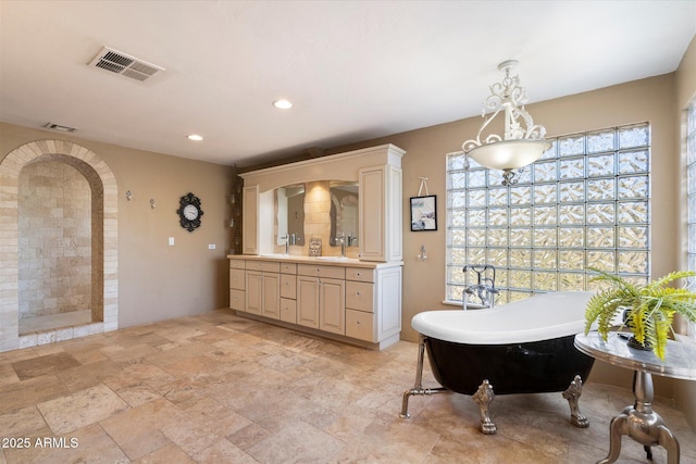 bathroom with vanity and a tub to relax in