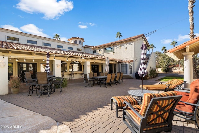 back of property featuring a patio and exterior bar