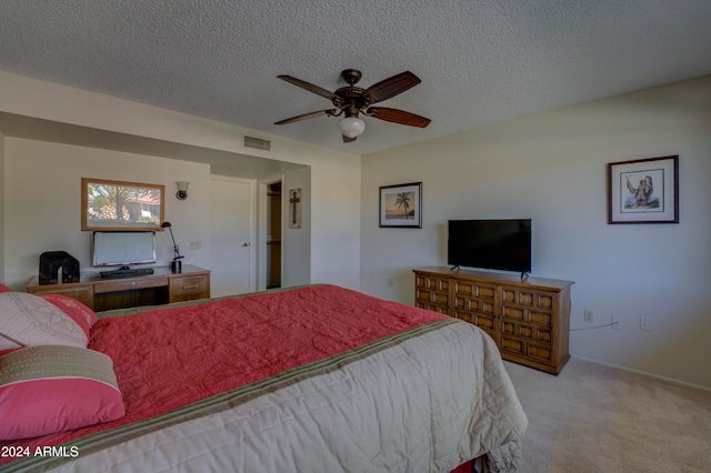 carpeted bedroom with ceiling fan and a textured ceiling