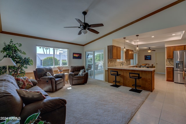 living room with ornamental molding, light tile patterned floors, lofted ceiling, and sink