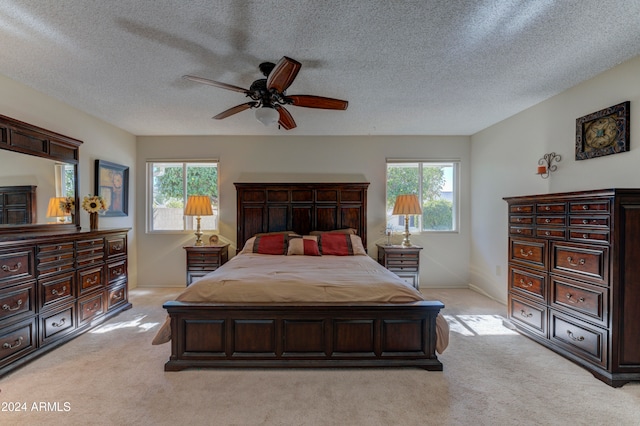 carpeted bedroom featuring multiple windows, ceiling fan, and a textured ceiling