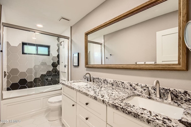 full bathroom featuring shower / bath combination with glass door, tile patterned flooring, vanity, and toilet