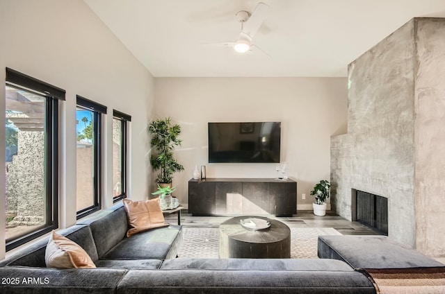 living room featuring ceiling fan, light hardwood / wood-style floors, and a fireplace