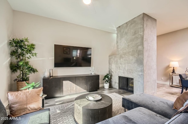 living room featuring hardwood / wood-style floors and a large fireplace