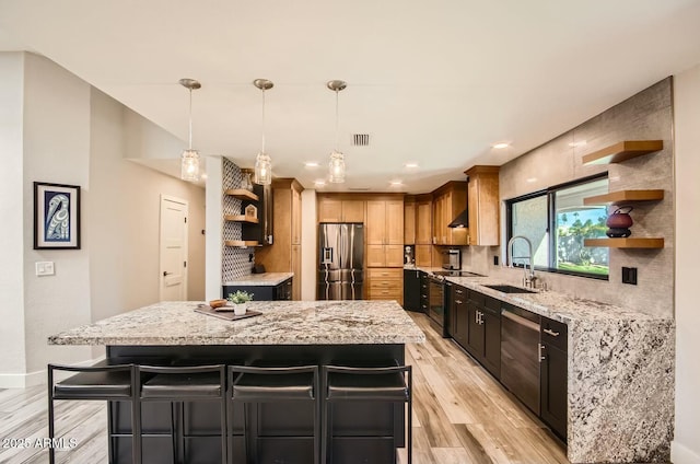 kitchen with a breakfast bar, a kitchen island, stainless steel appliances, and sink