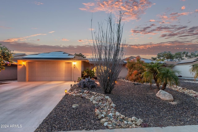 view of front of home featuring solar panels and a garage