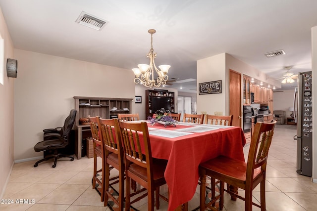 tiled dining area featuring ceiling fan with notable chandelier