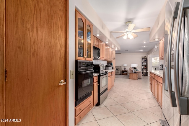 kitchen featuring light tile patterned flooring, decorative backsplash, ceiling fan, and black appliances